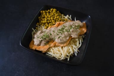 Chicken in mushroom sauce with vegetable spaghetti and peas
